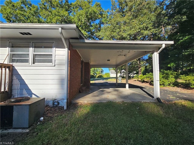 view of parking with a lawn and a carport