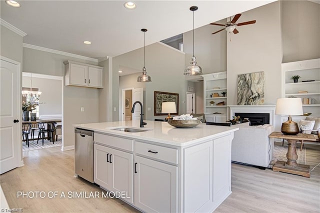 kitchen with sink, white cabinetry, a center island with sink, stainless steel dishwasher, and pendant lighting