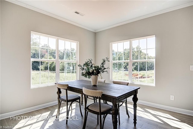 dining space with crown molding and hardwood / wood-style floors