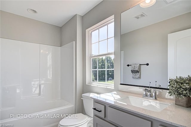 full bathroom featuring vanity, tub / shower combination, and toilet