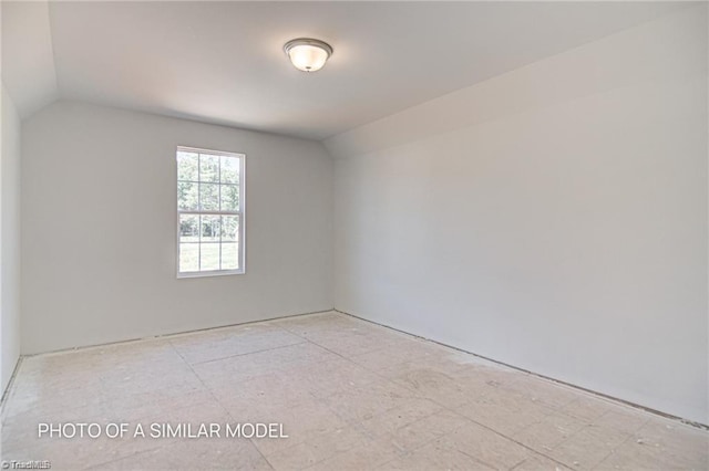 empty room featuring vaulted ceiling