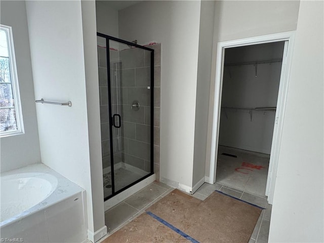 bathroom featuring plenty of natural light and separate shower and tub