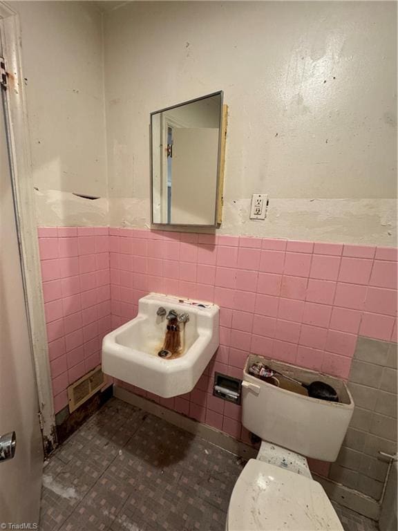 bathroom featuring tile walls, sink, and toilet