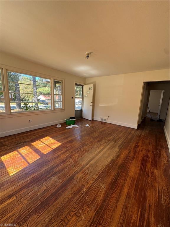 unfurnished living room featuring dark hardwood / wood-style flooring