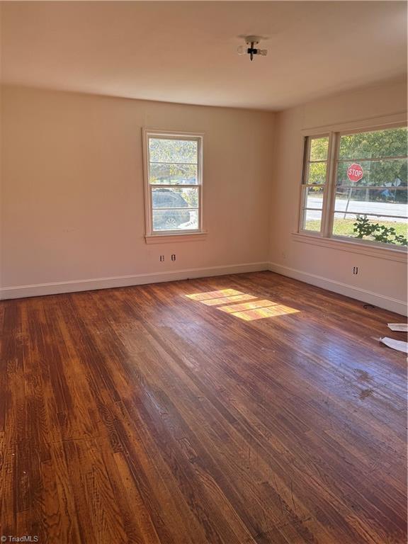 spare room featuring dark hardwood / wood-style flooring and a wealth of natural light