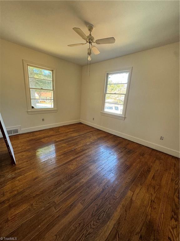 unfurnished room featuring dark hardwood / wood-style floors and ceiling fan