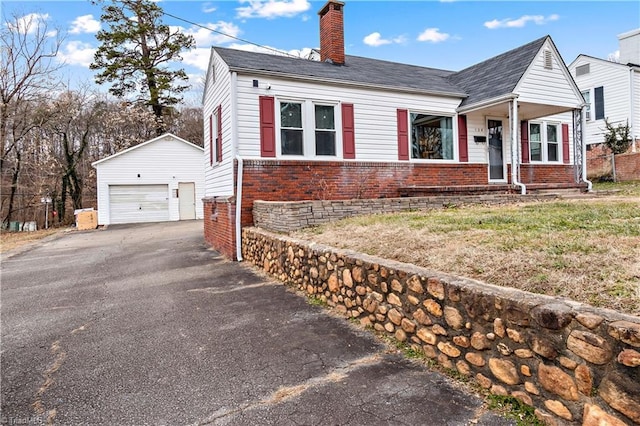 view of front of property featuring an outbuilding, a garage, and a front lawn