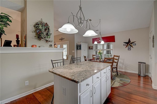 kitchen with white cabinetry, dark wood-type flooring, pendant lighting, and a kitchen island