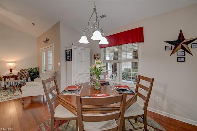 dining area featuring visible vents, wood finished floors, baseboards, french doors, and lofted ceiling