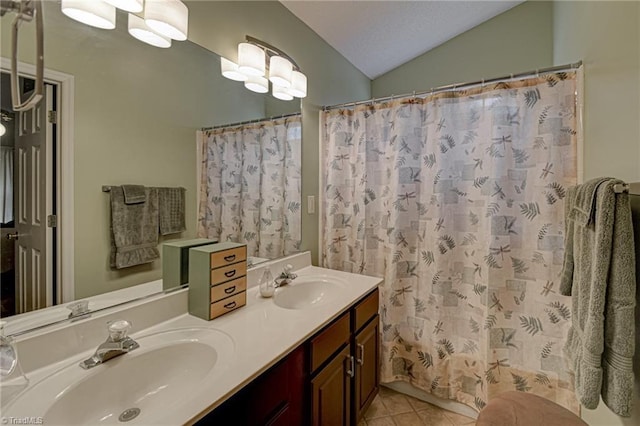 full bath featuring tile patterned floors, double vanity, lofted ceiling, and a sink