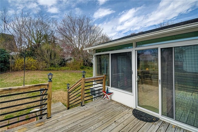 deck featuring a lawn and a sunroom