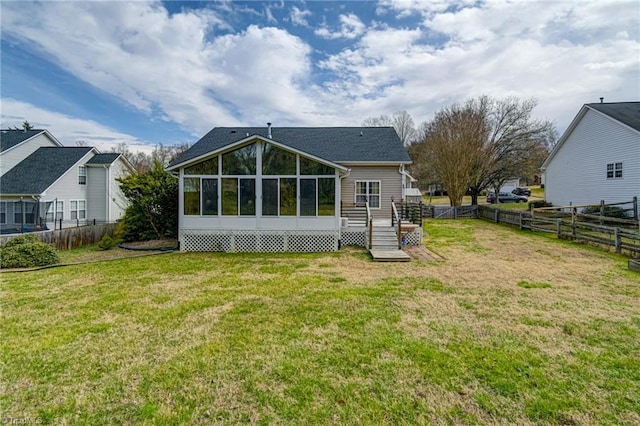 back of house with a lawn, a fenced backyard, and a sunroom