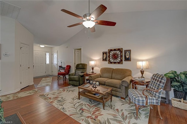 living area with vaulted ceiling, visible vents, ceiling fan, and wood finished floors