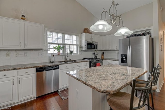 kitchen with dark wood-style floors, appliances with stainless steel finishes, white cabinetry, and a sink