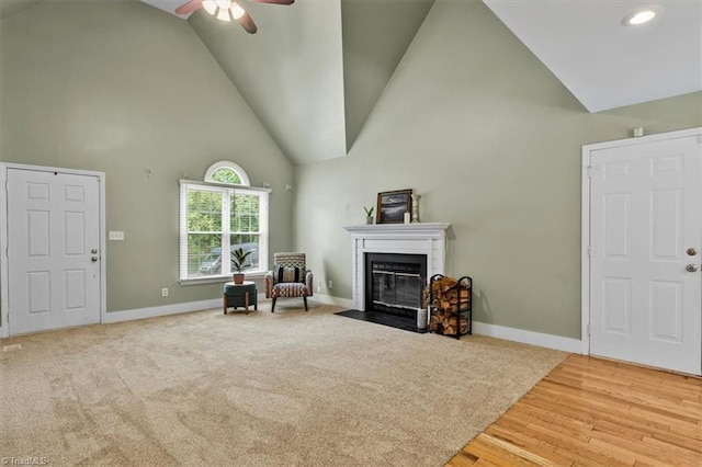 interior space featuring a ceiling fan, recessed lighting, baseboards, high vaulted ceiling, and a fireplace with flush hearth