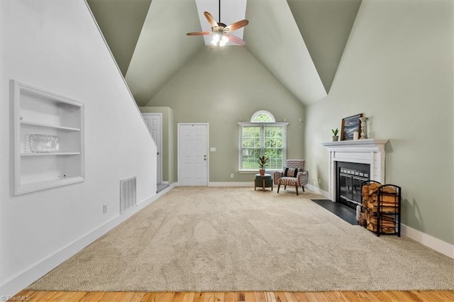 living area with ceiling fan, carpet flooring, visible vents, and a fireplace with flush hearth
