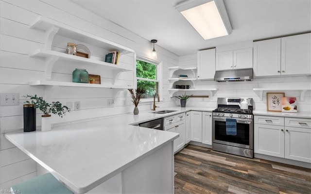 kitchen featuring a sink, a peninsula, stainless steel gas range oven, open shelves, and under cabinet range hood