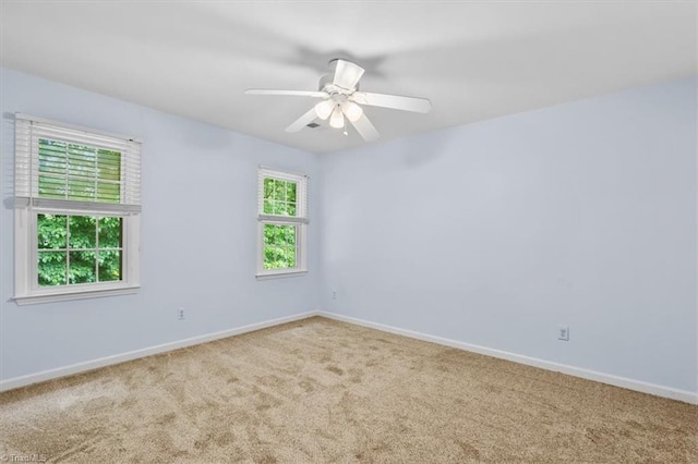 carpeted empty room featuring baseboards and ceiling fan