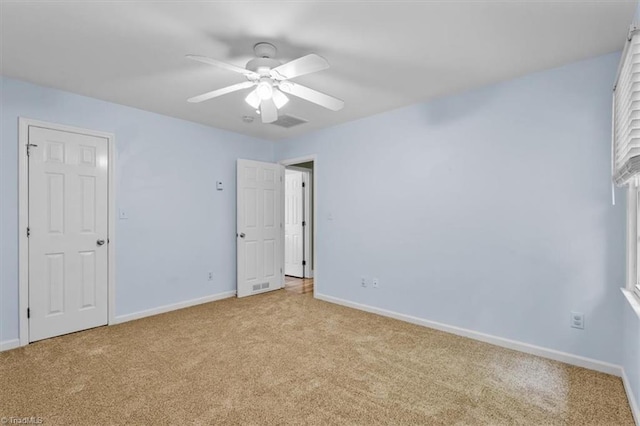 unfurnished bedroom with light colored carpet, baseboards, and ceiling fan