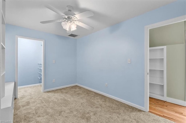 unfurnished bedroom with baseboards, a spacious closet, a closet, and carpet floors