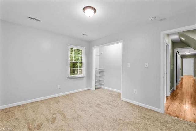 unfurnished bedroom featuring carpet flooring, a closet, visible vents, and baseboards