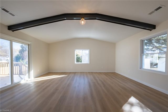 spare room featuring vaulted ceiling with beams and wood-type flooring