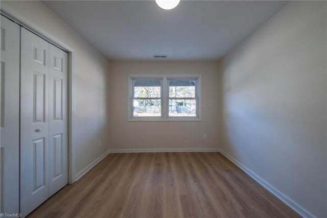 unfurnished bedroom with light hardwood / wood-style floors and a closet