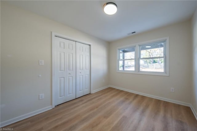 unfurnished bedroom featuring light wood-type flooring and a closet