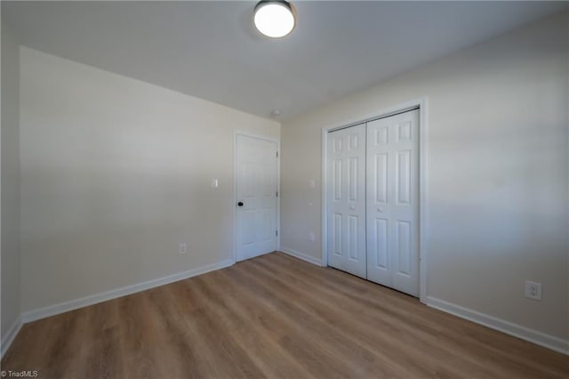 unfurnished bedroom featuring hardwood / wood-style floors and a closet