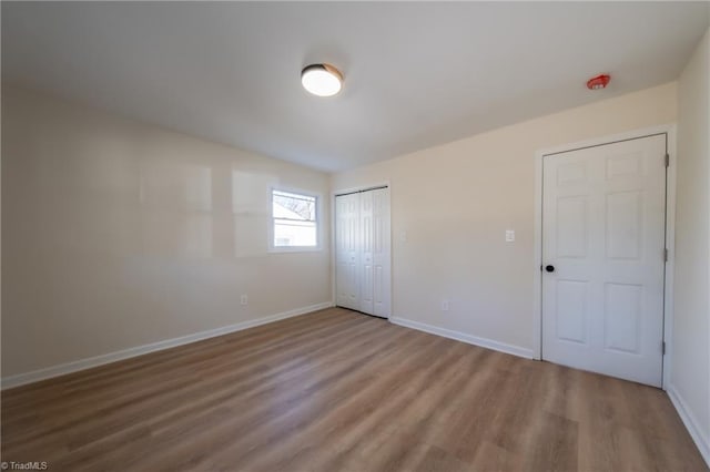 unfurnished bedroom featuring wood-type flooring and a closet