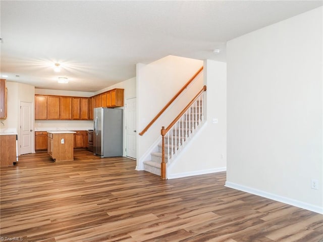 1307 Montreux Ct, Mebane, NC 27302 - kitchen with brown cabinets, wood finished floors, freestanding refrigerator, open floor plan, and a center island