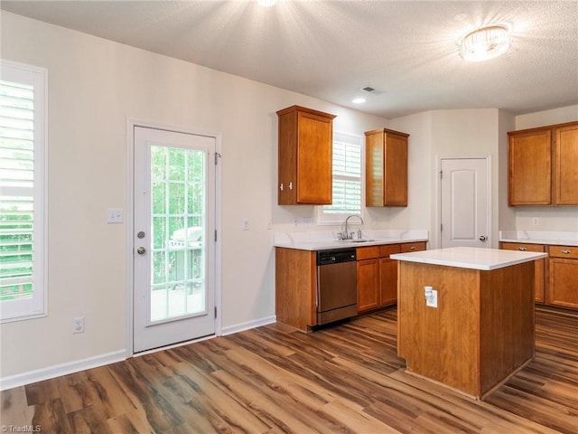 1307 Montreux Ct, Mebane, NC 27302 - kitchen with light countertops, stainless steel dishwasher, brown cabinetry, and dark wood-type flooring