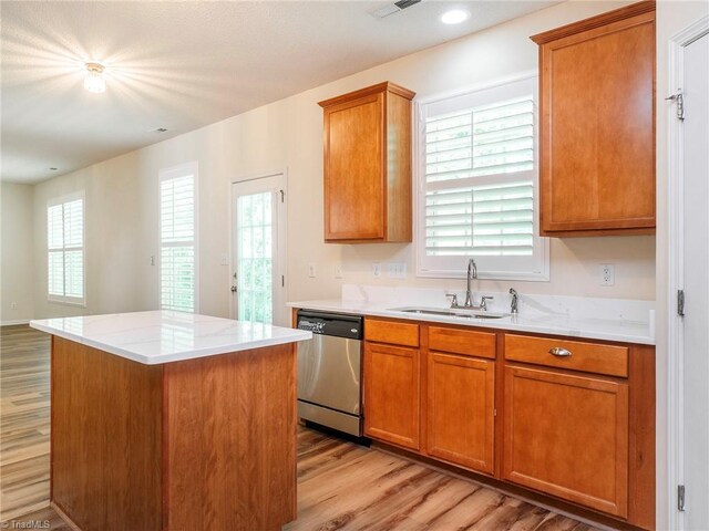 1307 Montreux Ct, Mebane, NC 27302 - kitchen with light wood-type flooring, stainless steel dishwasher, brown cabinetry, and a sink