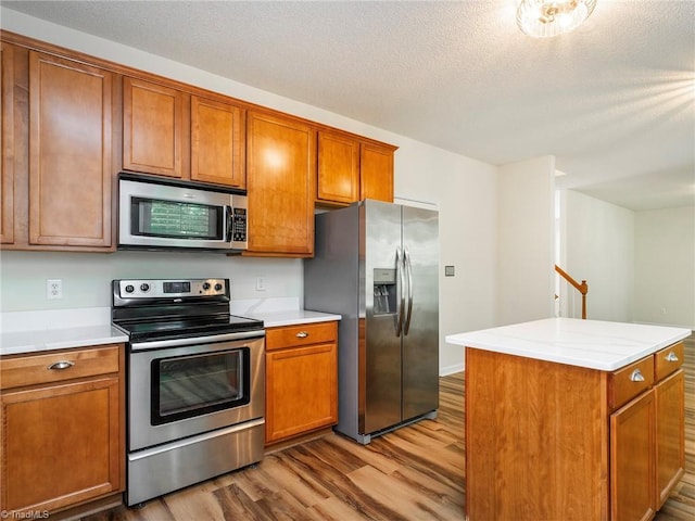 1307 Montreux Ct, Mebane, NC 27302 - kitchen featuring brown cabinets, light countertops, appliances with stainless steel finishes, and wood finished floors