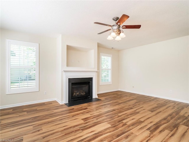 1307 Montreux Ct, Mebane, NC 27302 - unfurnished living room featuring a ceiling fan, baseboards, a fireplace with flush hearth, and wood finished floors
