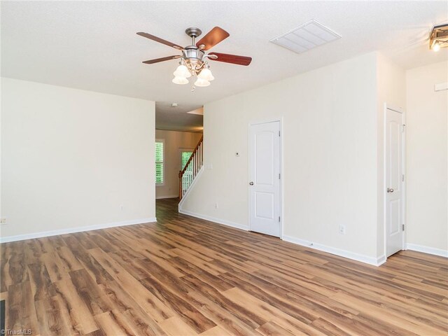 1307 Montreux Ct, Mebane, NC 27302 - unfurnished room featuring wood finished floors, visible vents, stairway, ceiling fan, and baseboards