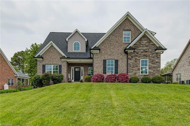 231 Plumstead Ln, Clemmons, NC 27012 - craftsman-style house featuring a front yard, brick siding, roof with shingles, and cooling unit