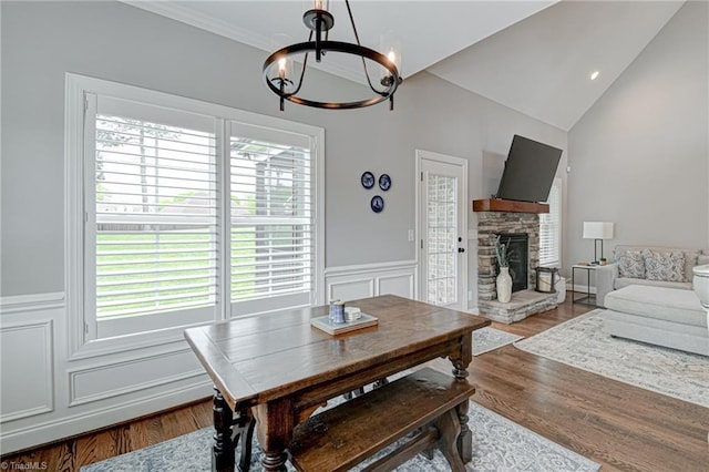 231 Plumstead Ln, Clemmons, NC 27012 - dining area featuring a chandelier, plenty of natural light, a fireplace, a wainscoted wall, and vaulted ceiling