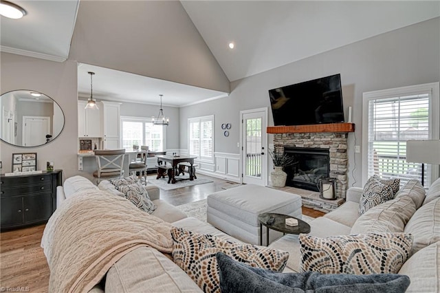 231 Plumstead Ln, Clemmons, NC 27012 - living room with light wood finished floors, lofted ceiling, a chandelier, a wainscoted wall, and crown molding