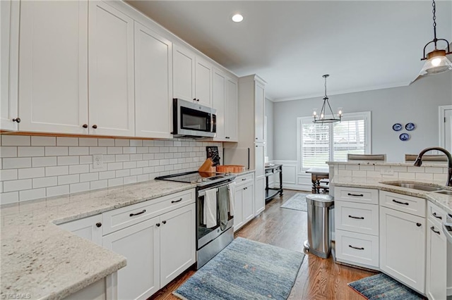 231 Plumstead Ln, Clemmons, NC 27012 - kitchen featuring appliances with stainless steel finishes, a sink, crown molding, light wood-type flooring, and white cabinets