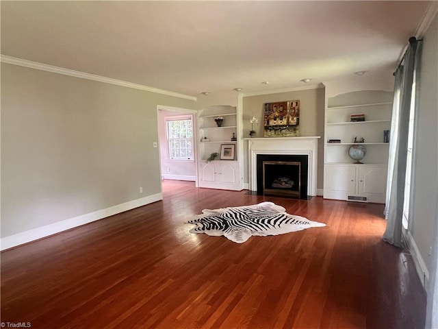 508 Audubon Dr, Greensboro, NC 27410 - living room with built in shelves, wood finished floors, crown molding, and a fireplace with flush hearth