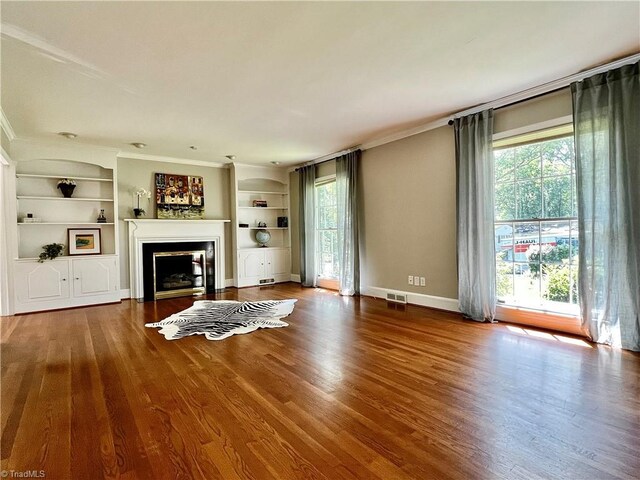 508 Audubon Dr, Greensboro, NC 27410 - unfurnished living room with built in features, a fireplace, wood finished floors, and crown molding
