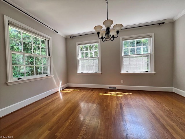 508 Audubon Dr, Greensboro, NC 27410 - spare room featuring a chandelier, wood finished floors, ornamental molding, and healthy amount of natural light