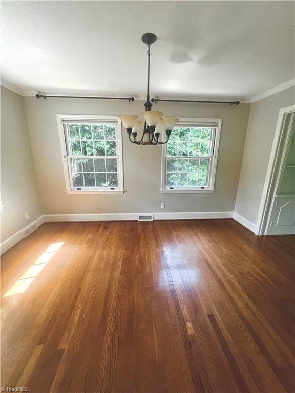 508 Audubon Dr, Greensboro, NC 27410 - unfurnished dining area featuring a chandelier, healthy amount of natural light, ornamental molding, and wood finished floors