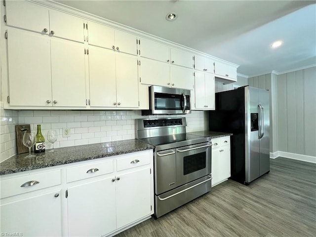 508 Audubon Dr, Greensboro, NC 27410 - kitchen with appliances with stainless steel finishes, crown molding, tasteful backsplash, wood finished floors, and white cabinetry