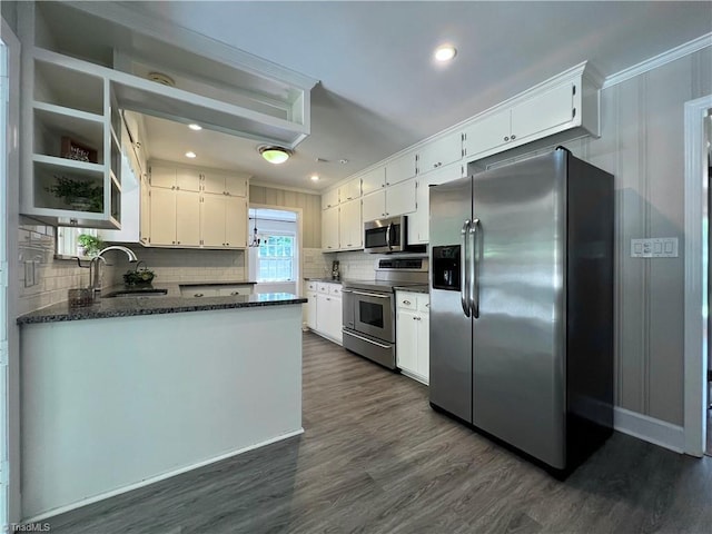 508 Audubon Dr, Greensboro, NC 27410 - kitchen with stainless steel appliances, dark wood-type flooring, tasteful backsplash, white cabinetry, and crown molding