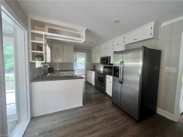 508 Audubon Dr, Greensboro, NC 27410 - kitchen with appliances with stainless steel finishes, dark wood-type flooring, white cabinets, dark countertops, and crown molding
