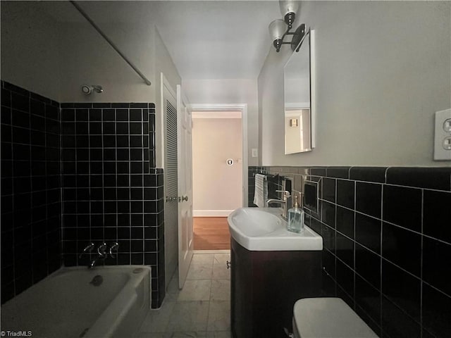 508 Audubon Dr, Greensboro, NC 27410 - full bath featuring vanity, marble finish flooring, tile walls, shower / tub combination, and wainscoting