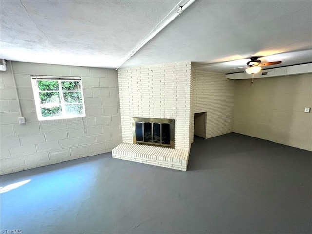 508 Audubon Dr, Greensboro, NC 27410 - unfurnished living room featuring concrete floors, a brick fireplace, concrete block wall, and a ceiling fan