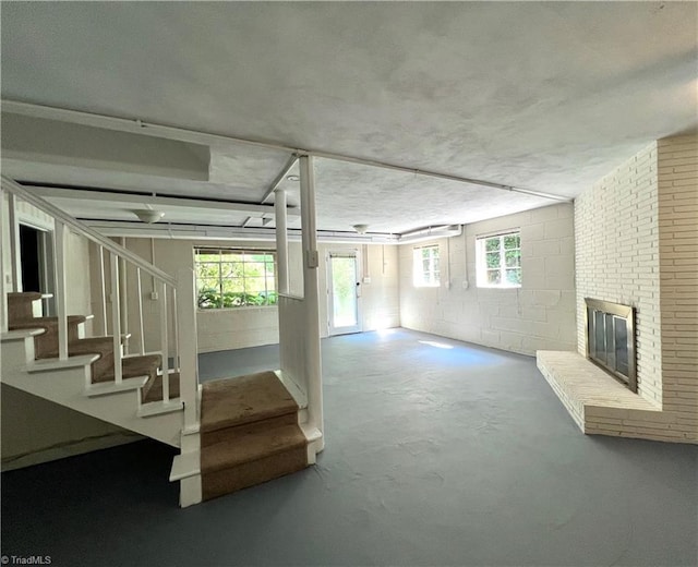 508 Audubon Dr, Greensboro, NC 27410 - below grade area with stairs, concrete block wall, healthy amount of natural light, and a brick fireplace